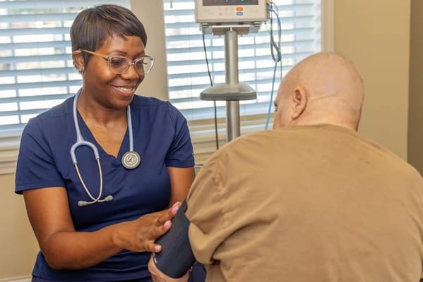 Nurse taking blood pressure of a resident