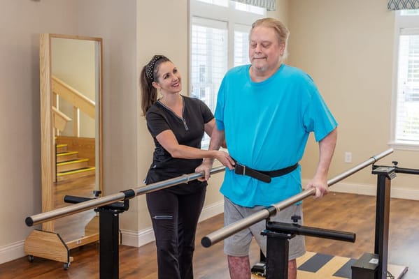 A staff member assisting a resident with therapy exercises