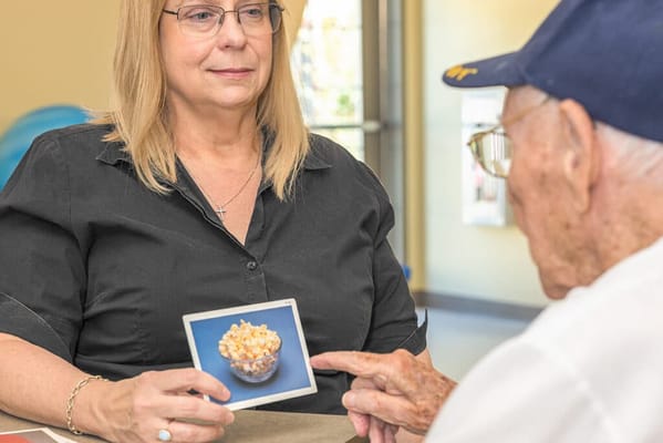 Staff member showing a photo of food to a resident