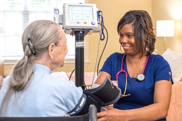 Nurse taking a resident's blood pressure in a warm room