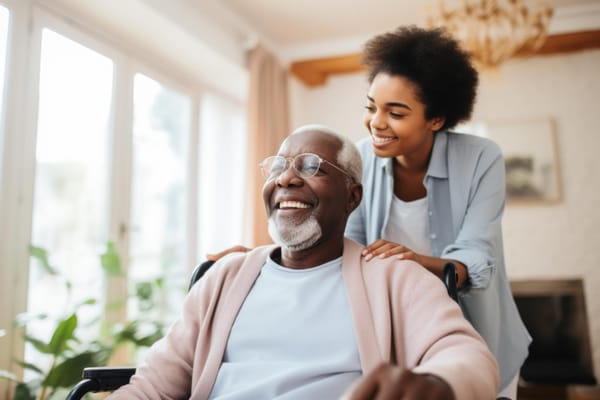 Resident and staff member smiling in a bright interior