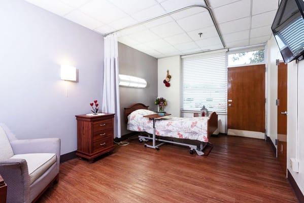 Bright interior of a private resident room with a bed