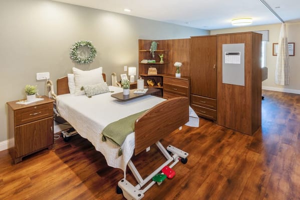 A senior living room with a bed and wooden furniture