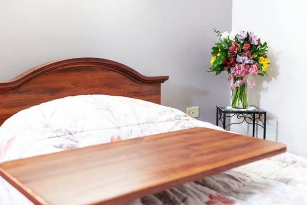 A cozy resident room with flowers and a bed