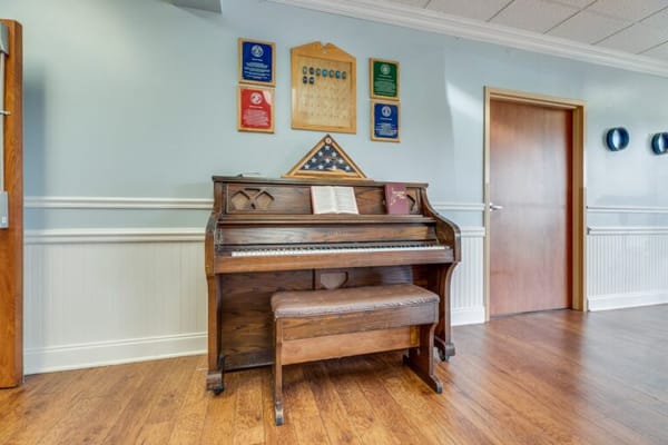 Piano in a hallway decorated with awards