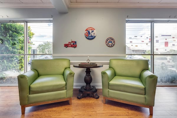 Two green armchairs in a bright lobby area