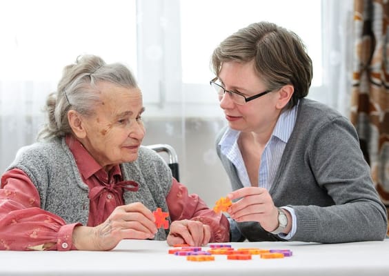 Resident and staff engaged in a puzzle activity