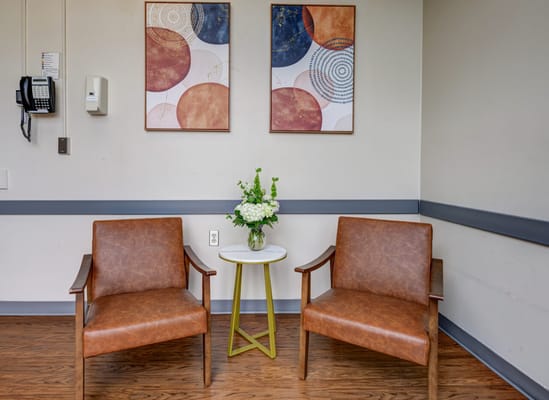 Two chairs and a table in a bright waiting area