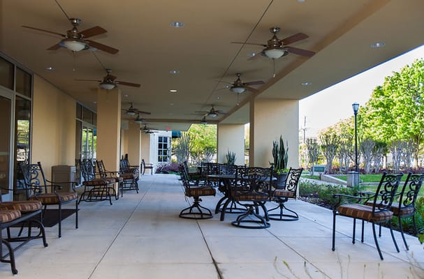 Covered patio area with seating and ceiling fans