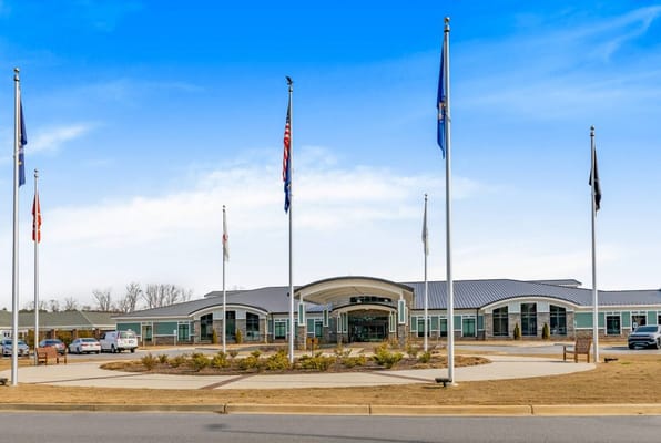 Front exterior of a senior living facility with flags