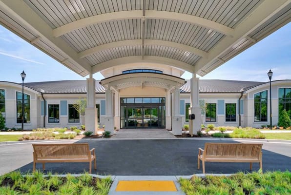 Exterior view of a nursing home entrance with benches