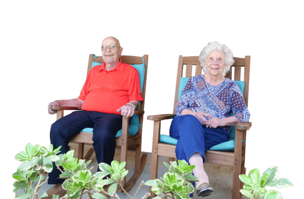Two seniors relaxing in rocking chairs on a porch