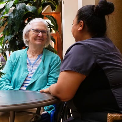 A resident and staff member having a warm conversation