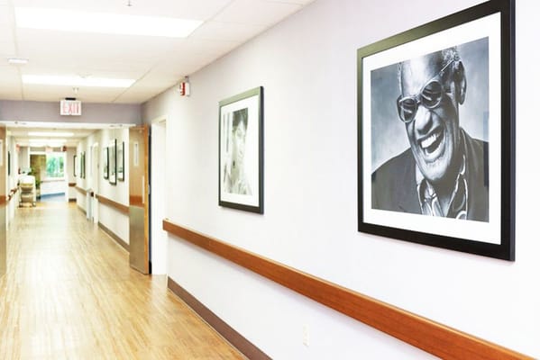 A hallway with framed black and white portraits