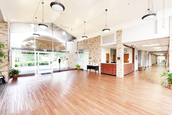 Spacious lobby area with wooden floors and large windows
