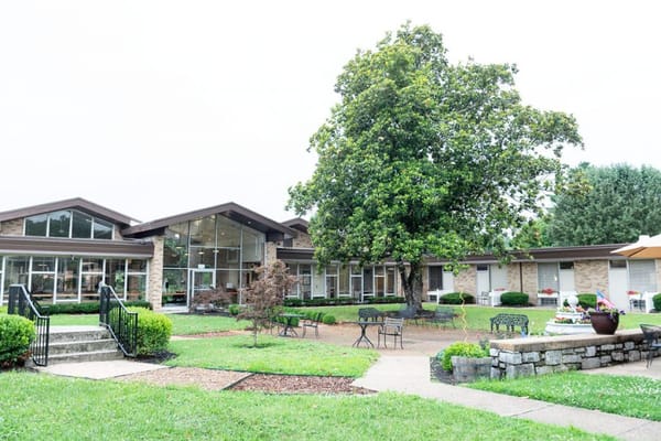 Exterior view of a senior living facility with outdoor seating