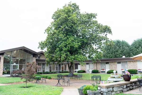 Exterior view of a senior living facility with gardens