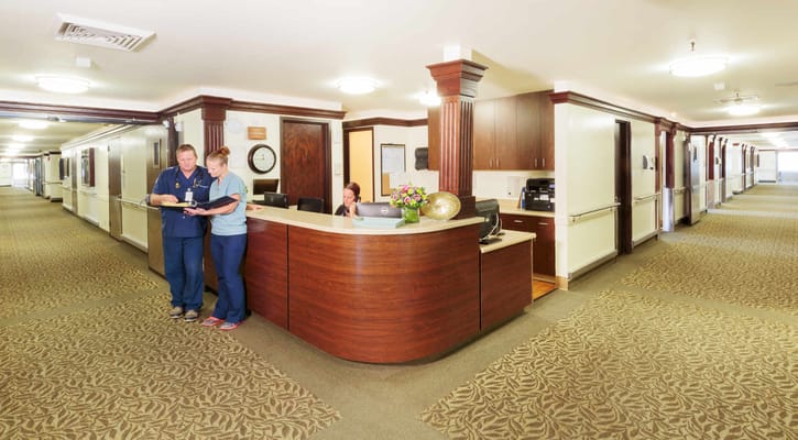 Staff members assisting residents at the reception area