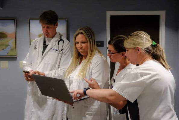 Healthcare staff collaborating on a laptop