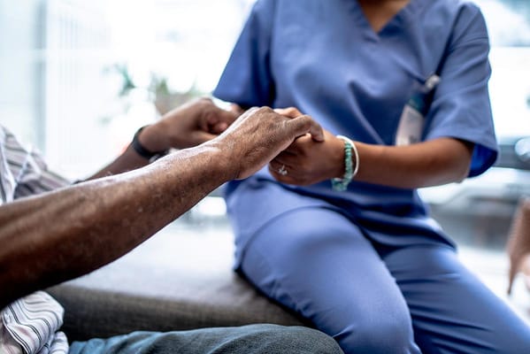 Caregiver holding hands with a resident in a cozy setting