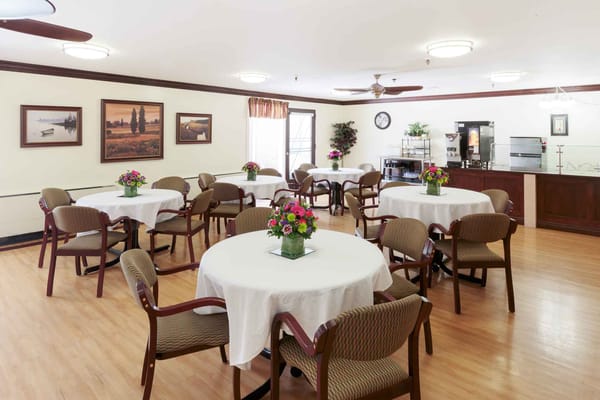 Bright dining room with tables set for residents