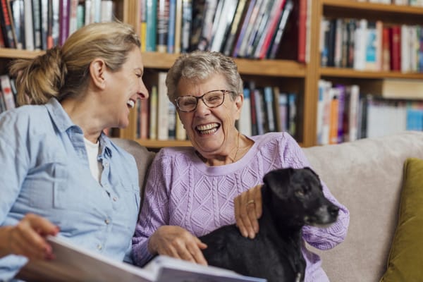 Residents enjoying a moment with a dog in the library