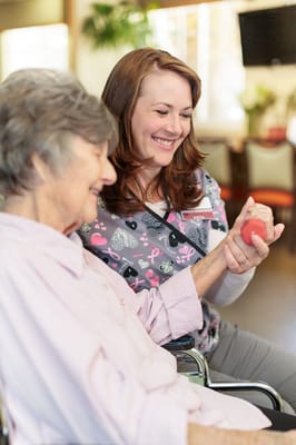 Staff member engaging with a resident during an activity