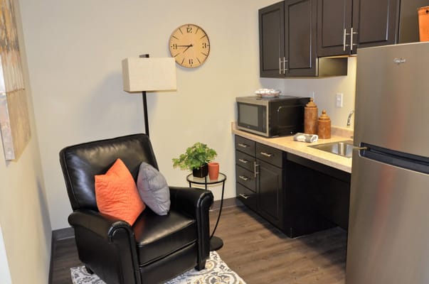 Cozy resident room with a chair and kitchen area