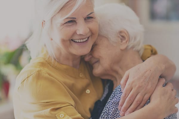A caregiver hugging a resident warmly