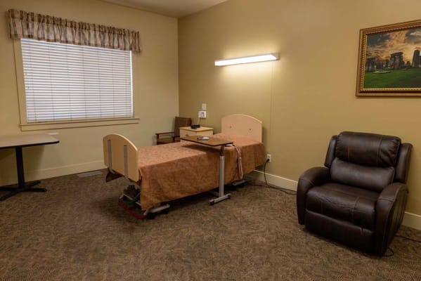 Simple private room with a bed and chair