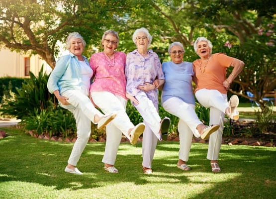 Five happy seniors posing in a garden