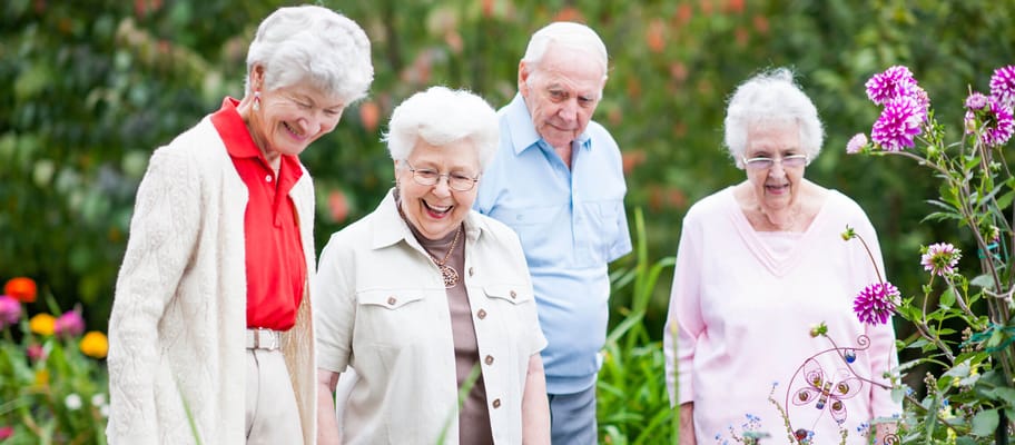 Residents enjoying gardening in a vibrant flower garden