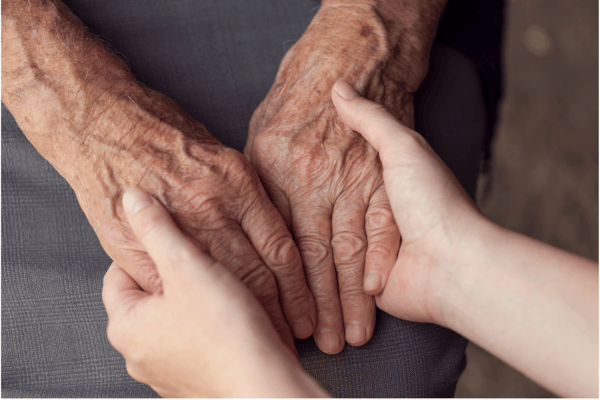 Close-up of elder hands being held