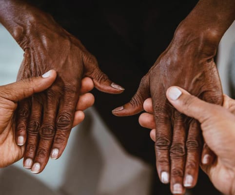 Hands of caregivers and a resident in a supportive touch