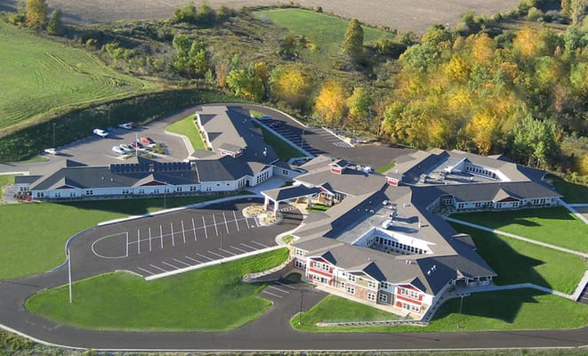 Aerial view of a assisted living facility with parking and landscaping