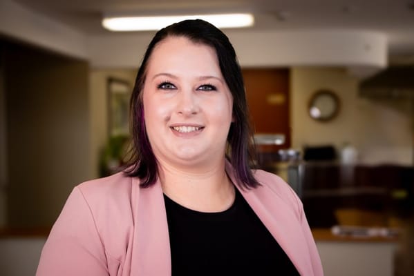 Staff member smiling in a warm interior setting
