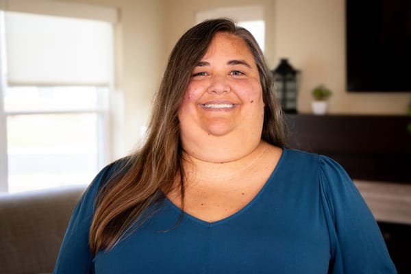 A staff member smiling in a well-lit common area