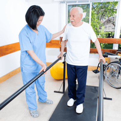 A caregiver assisting an elderly man on a walking apparatus