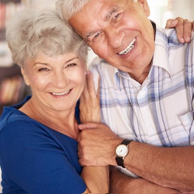 Smiling elderly couple embracing in a bright setting