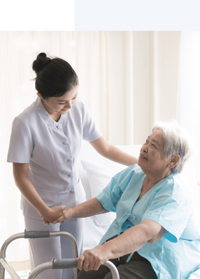 Healthcare staff assisting a senior resident indoors