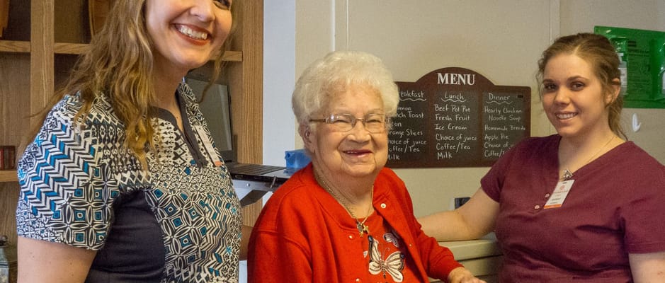 Two staff members with a resident in a cozy interior