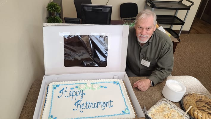Resident celebrating retirement with a cake
