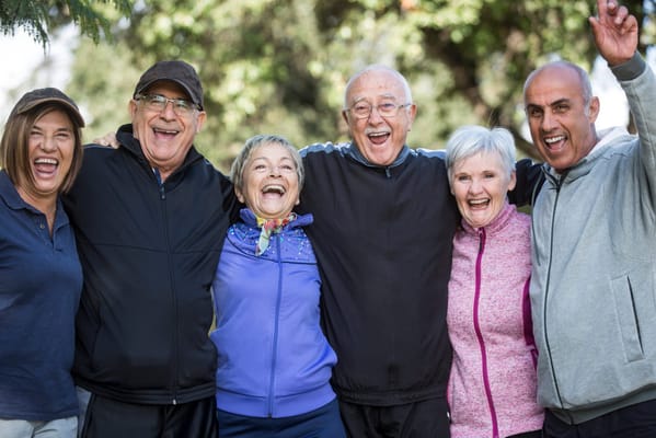 Group of seniors laughing together in an outdoor setting