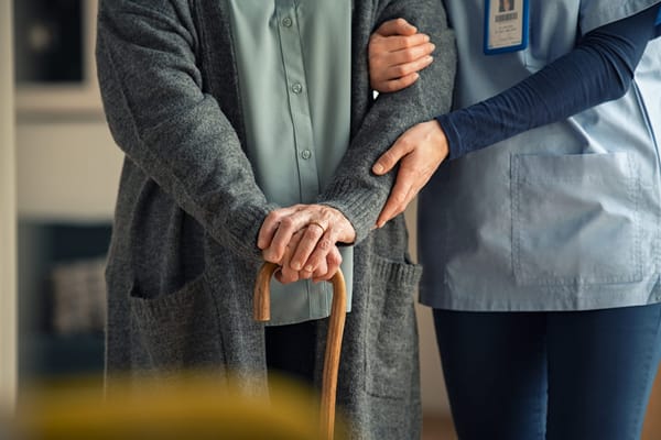 A caregiver assisting an elderly resident indoors