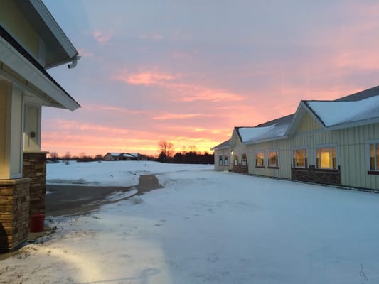 Building exterior with snow and sunset in background