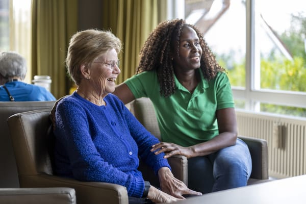 A resident and staff member enjoying a conversation indoors