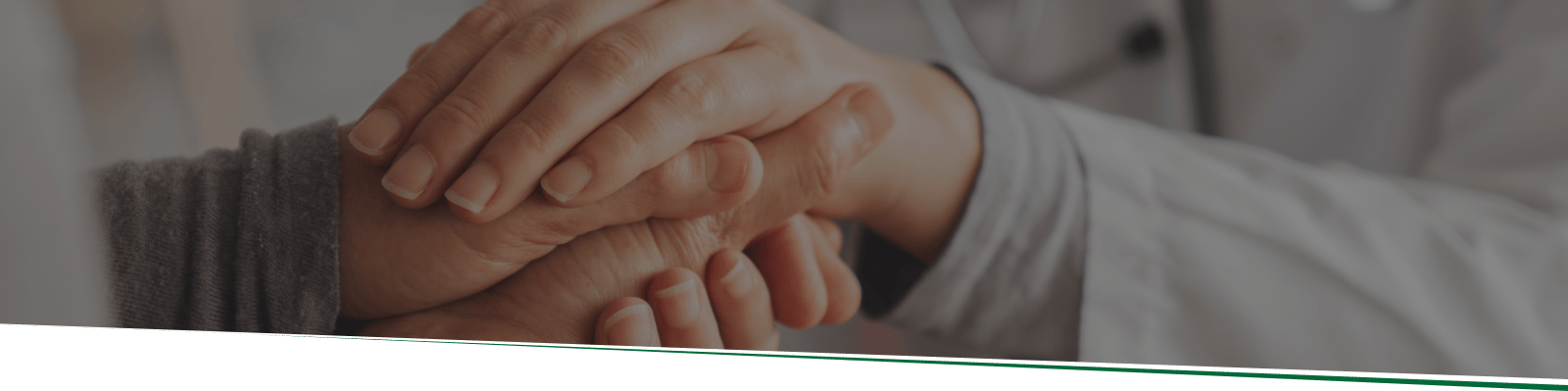 A healthcare professional holding a resident's hand, showing support