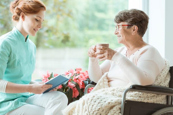 A caregiver interacting with a resident with flowers in the background