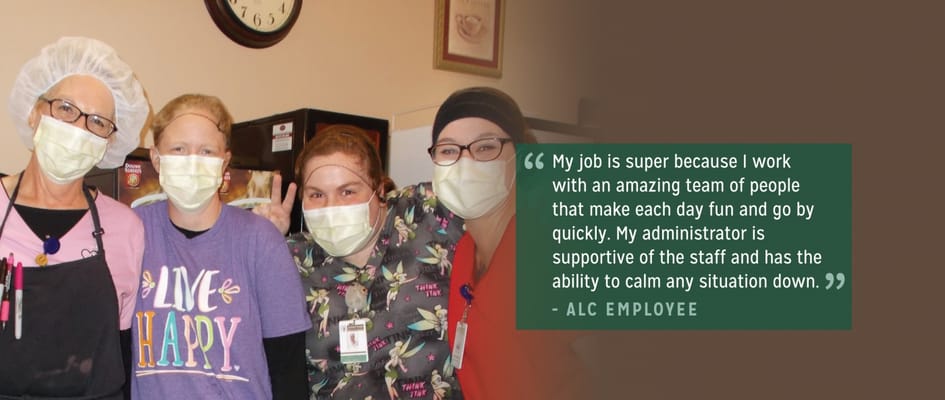 Staff members posing together in the kitchen