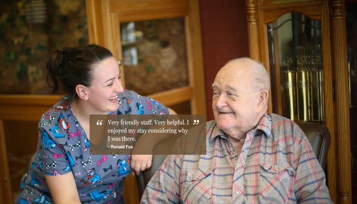 A staff member interacting with a resident, smiling.